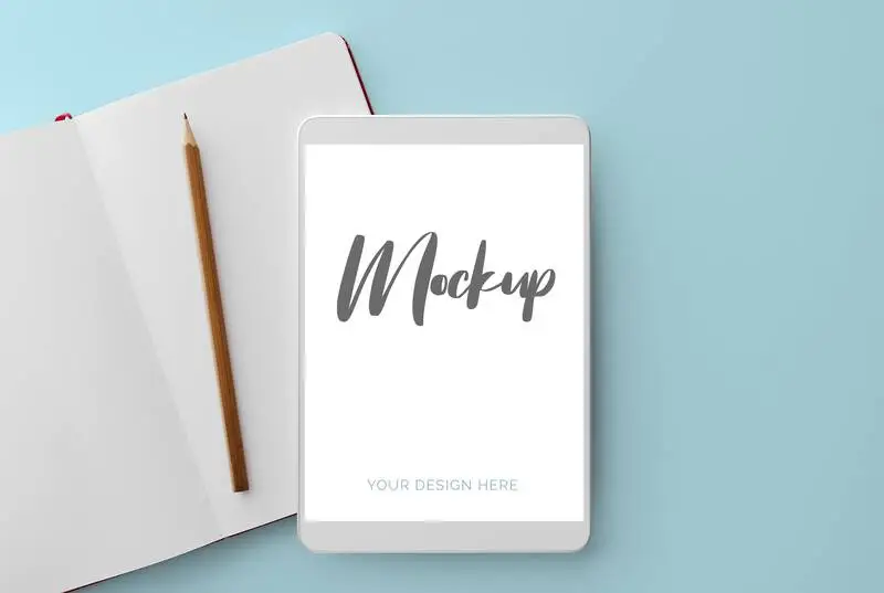 White Tablet on Blue Background with Notebook and Pencil Mockup