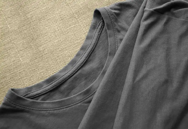 Grey T-Shirt on Fabric Surface