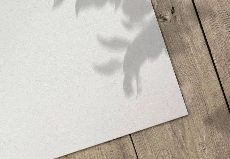 Paper Sheet on Wooden Surface with Shadow