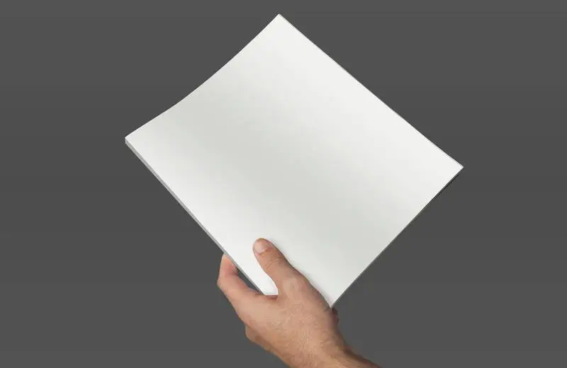 Isolated Hand Holding a Magazine on a Grey Background