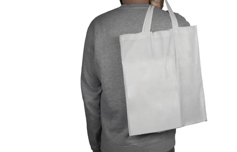 Image of a Model with a Blank Tote Bag Over White Surface