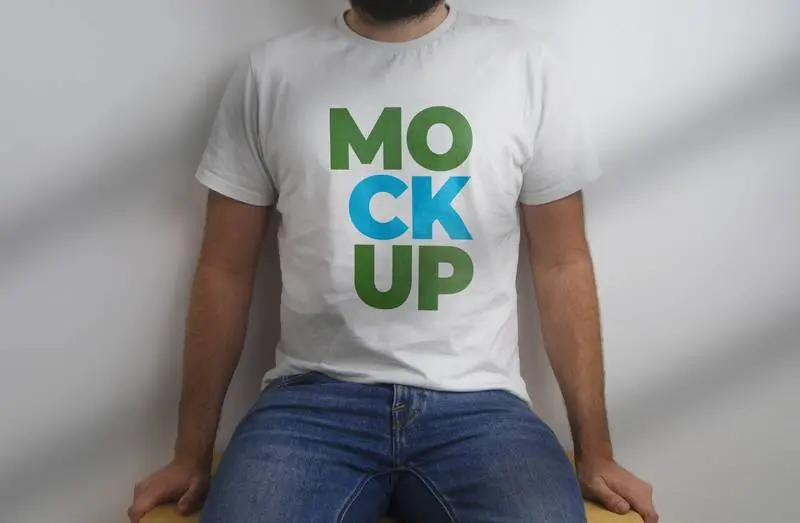 Mockup of Model Sitting with White T-Shirt