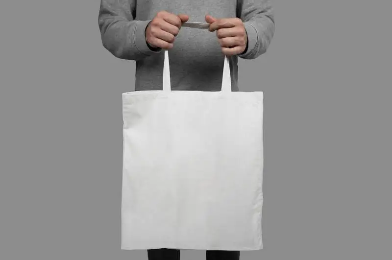 Model Holding a Tote Bag on a Gray Background