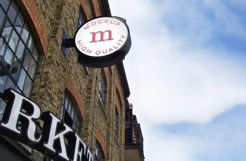 Logo Mockup on Brick Building Frontage with Cloudy Skies