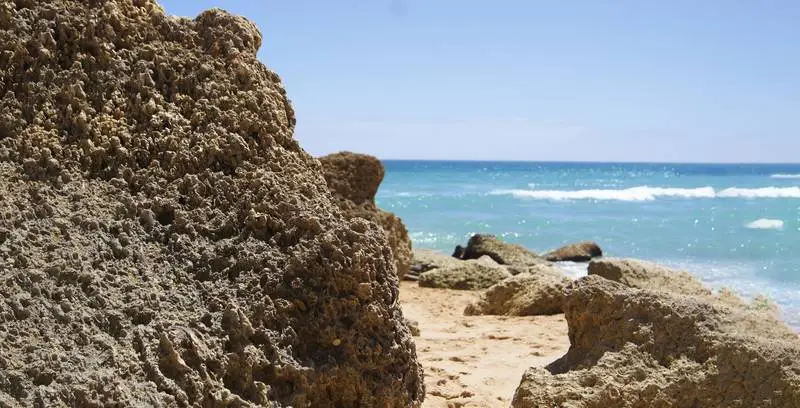 Photo of Rocks on a Beach with Sea in the Background