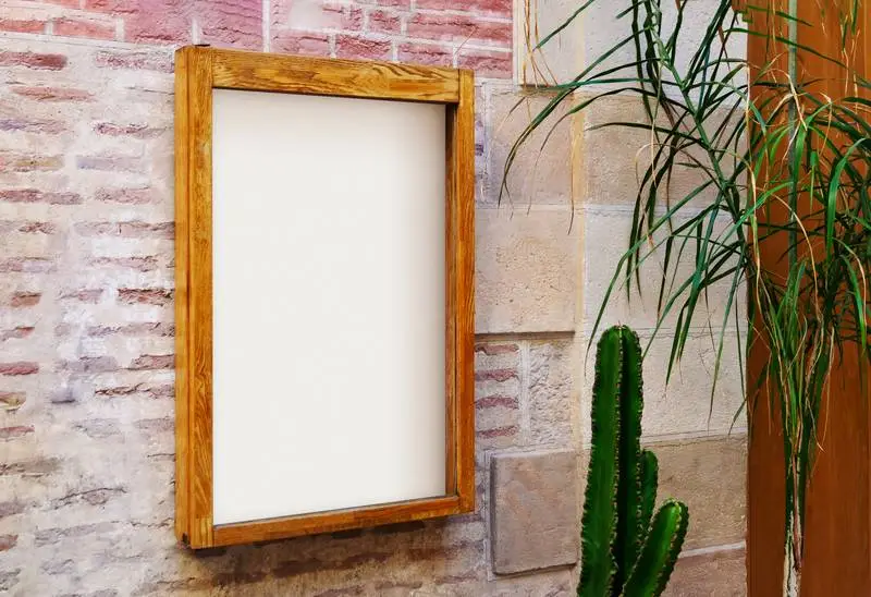 White Poster in a Wooden Frame on a Stone Wall