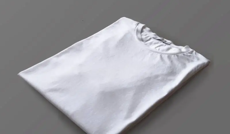 Folded White T-shirt Over Wood Surface