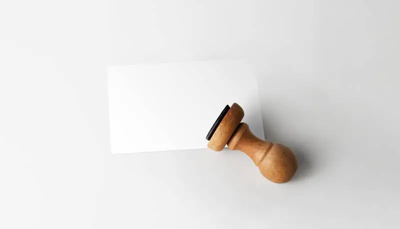 Rubber Stamp with Card Over White Surface
