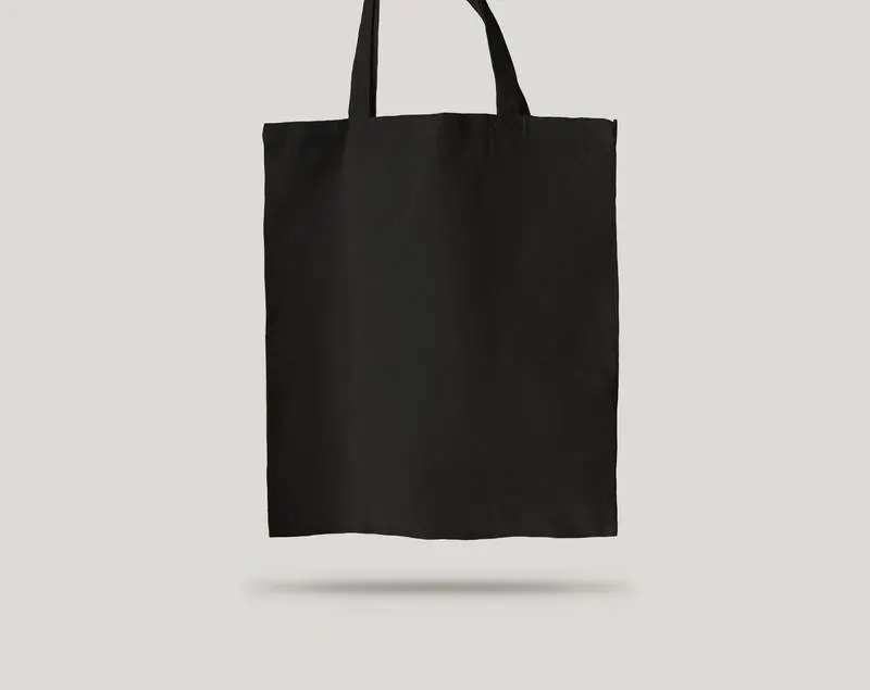 Plain Black Tote Bag Hanging Over a Light Background