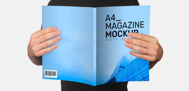 Mockup of Open Magazine Held by Model with Grey Background