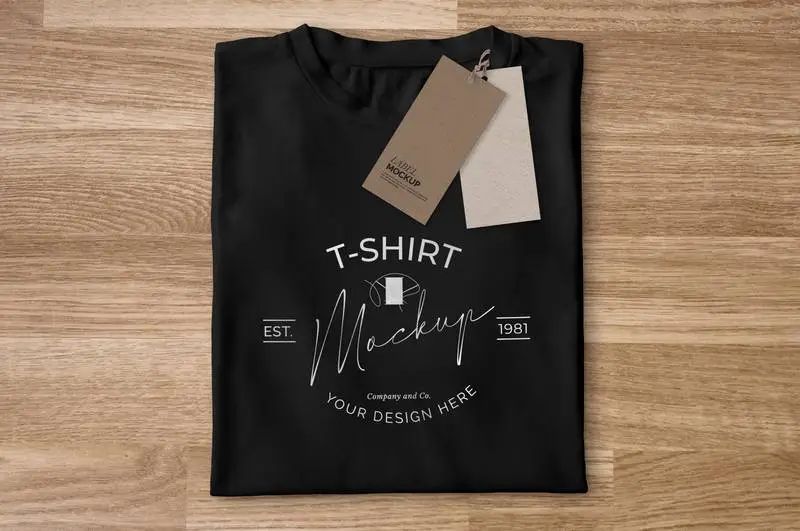 Mockup of Folded Black T-Shirt with Labels on a Wooden Background