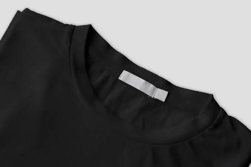 Photo of Folded Black T-Shirt with White Label Isolated
