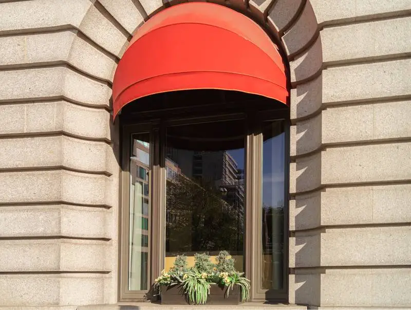 Photo of a Classic Window with Stone Façade and Red Awning