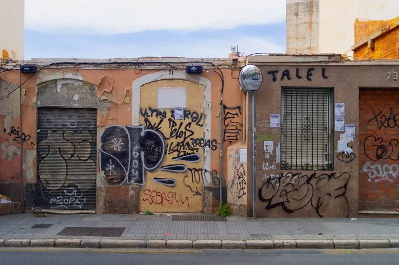 Photo of an Abandoned Building with Graffiti and Cloudy Sky