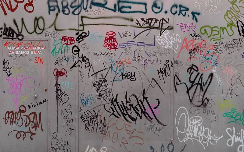 Photo of a Dirty Outdoor Metal Fence Painted with Graffiti