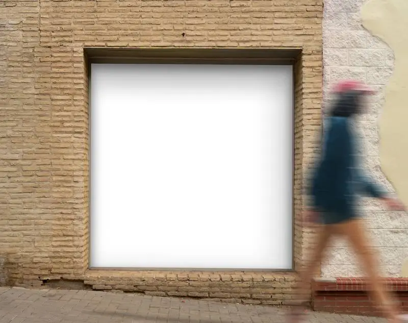 Square White Poster in Brick Niche in Street with Walking Person