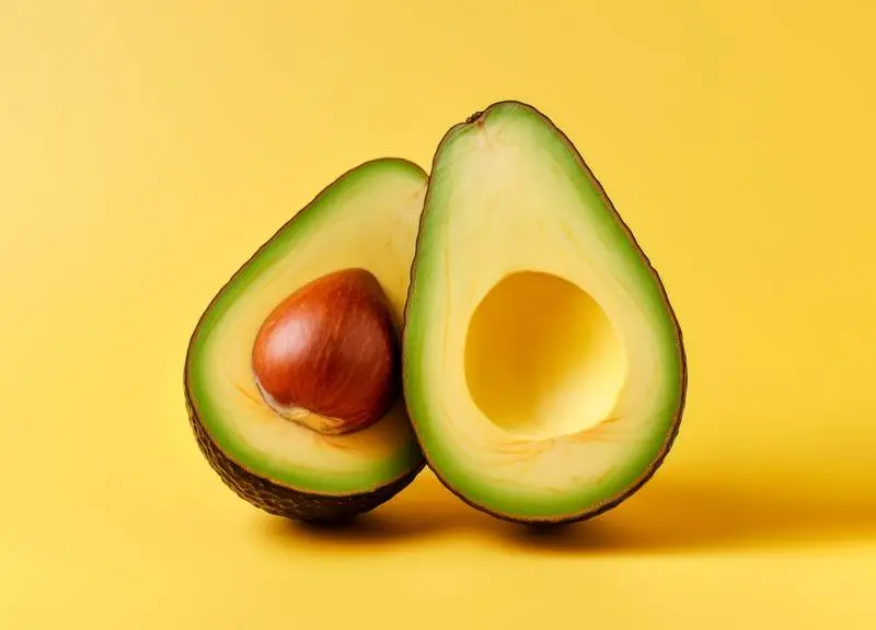 Image of Cut Avocado on Yellow Background