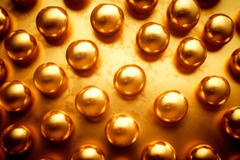 Photo of Raw Gold Spheres on a Golden Surface