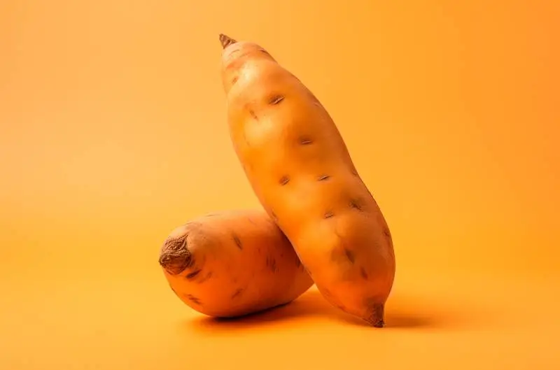 Realistic Image of a Pair of Sweet Potatoes on a Colourful Background