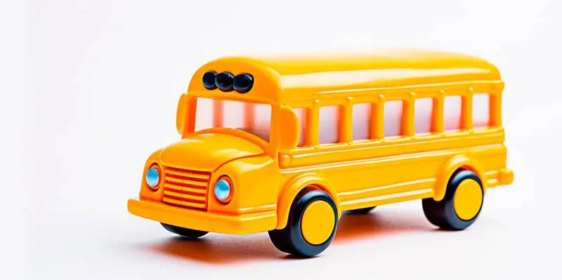 Image of a Yellow Toy School Bus in Profile on a White Background