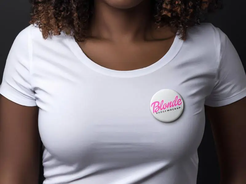 Mockup of a White Badge on a Curly-Haired Woman Wearing a White T-Shirt
