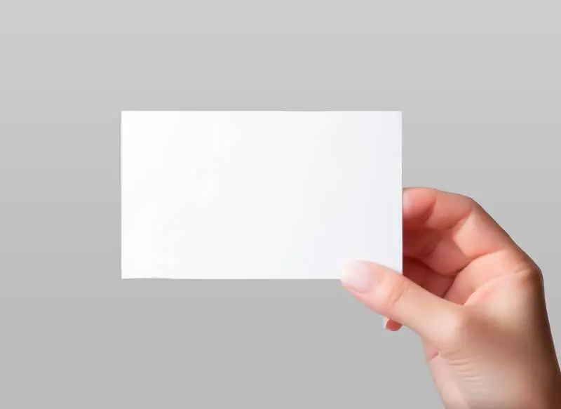 Female Hand Holding a Blank Business Card Isolated on a Grey Background