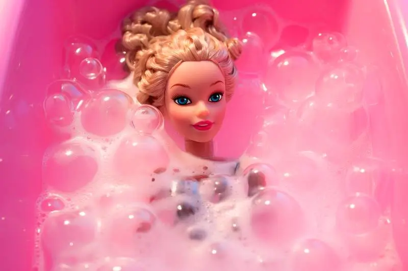 Doll Girl Bathing in a Pink Plastic Bathtub