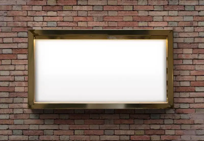 Whiteboard with Golden Frame on Brick Wall