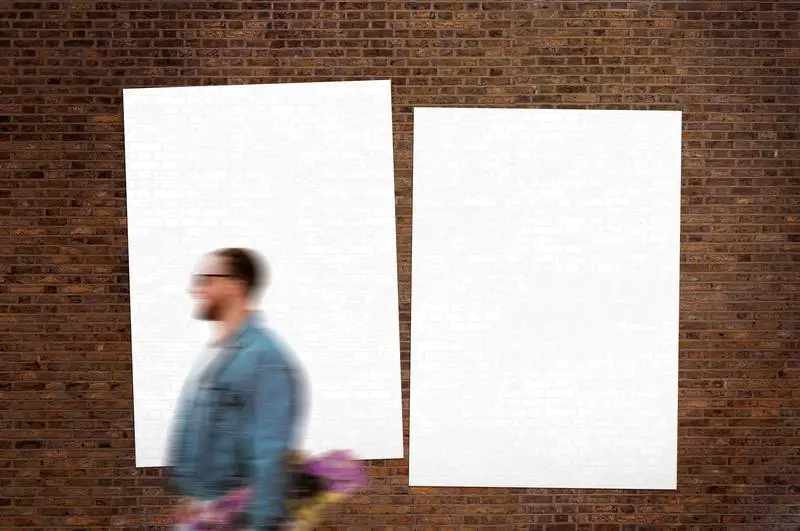 Pack of Glued White Poster over Brick Wall with Pedestrian