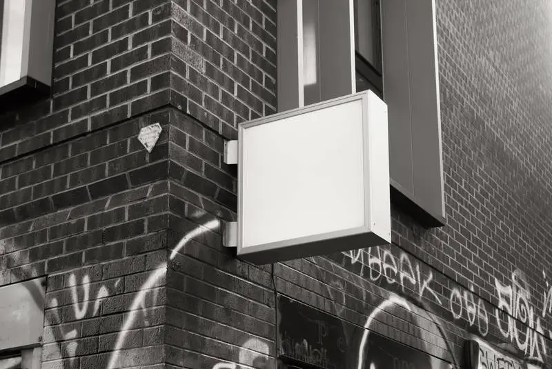 Square Street Sign on Black and White Brick Building