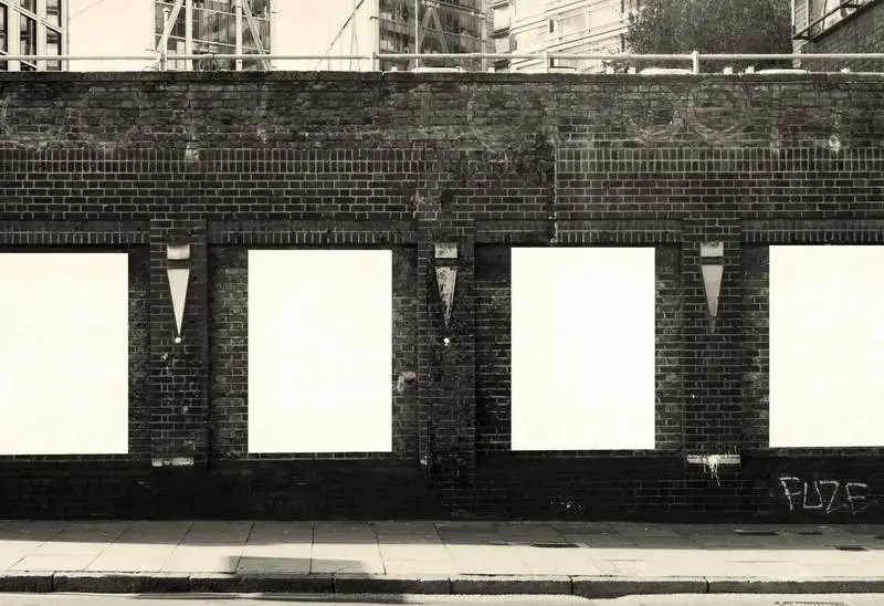 Collection of Posters on a Black and White City Brick Wall
