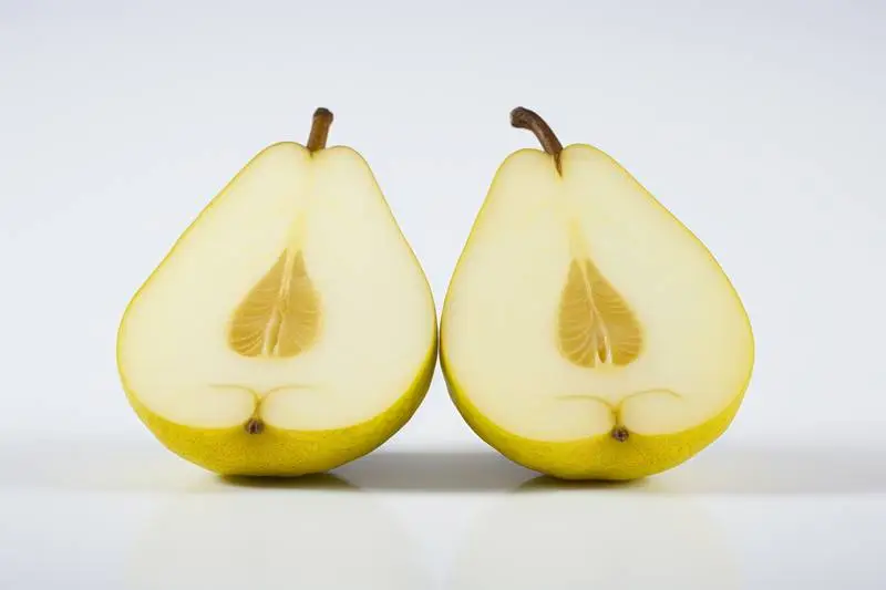 Picture of a Pear Cut in Half on a White Background