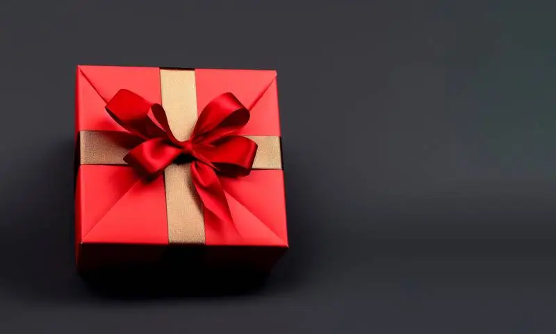 Image of Red Gift Box With Gold Ribbon on Dark Background