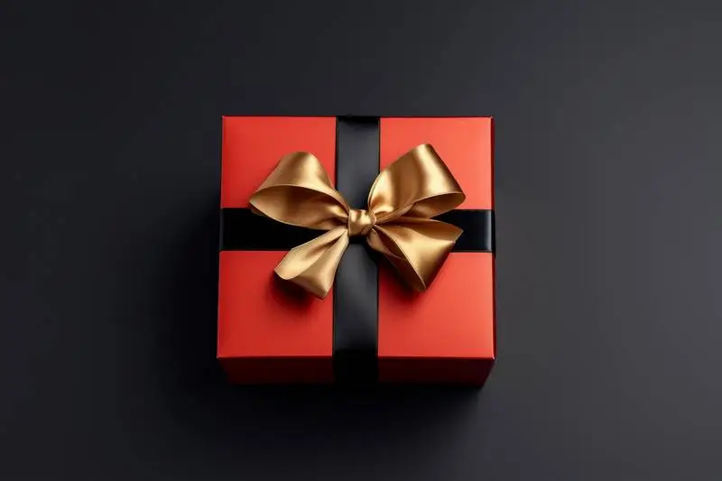 Photo of Red Box With Gold Ribbon on Dark Background