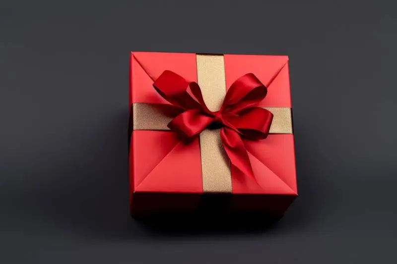 Image of Red Box With Red Ribbon on Dark Background