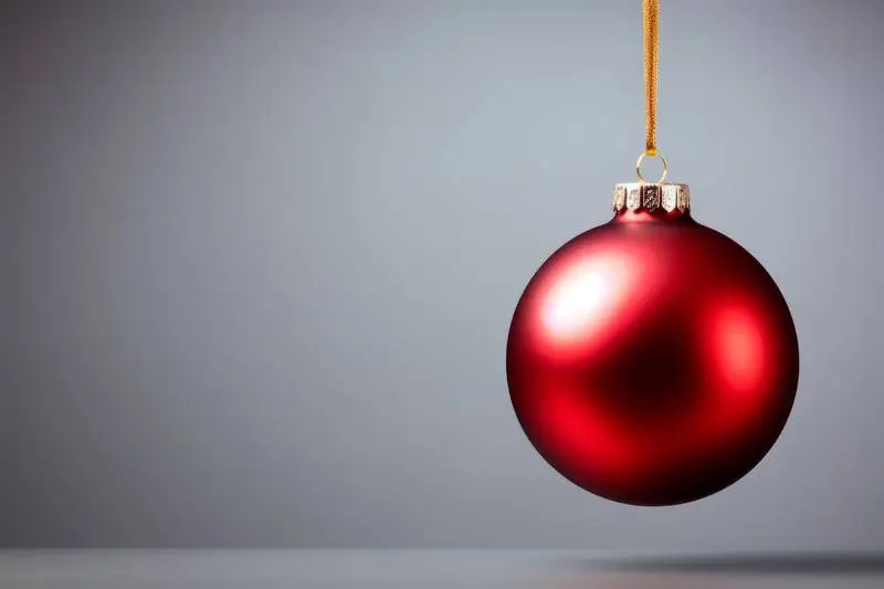 Image of Red Christmas Ball Hung With Gold Rope on Grey Background