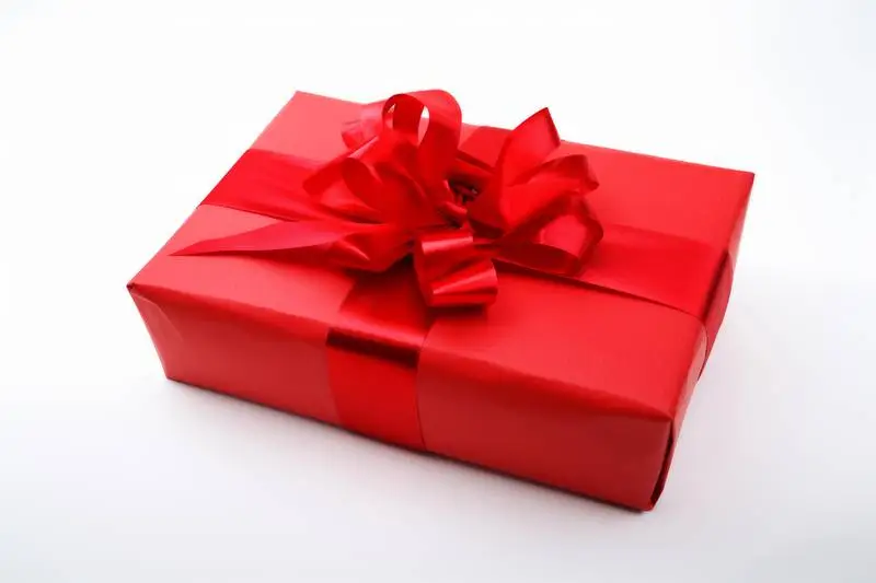 Photo of Red Gift Box Wrapped in Red Ribbon on White Background