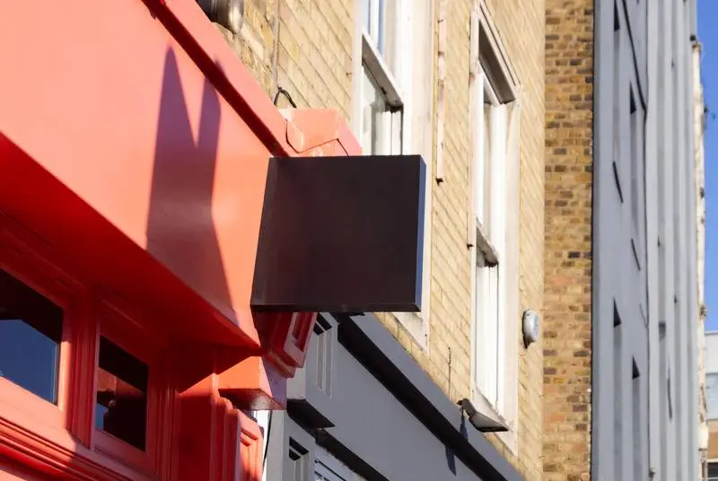 Black Street Sign on Classic Red Façade