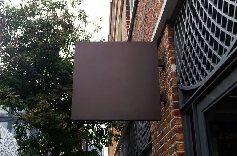 Dark Wall Sign on Brick Façade