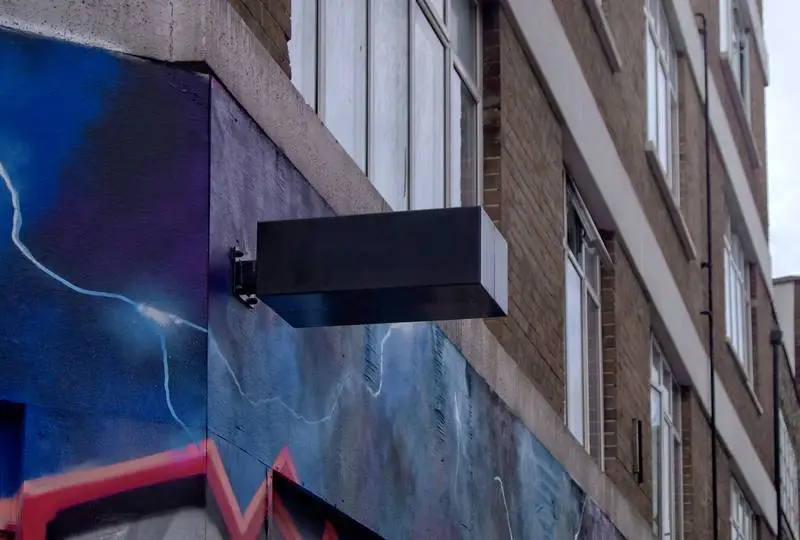 Dark Wall Sign on Façade with Graffiti
