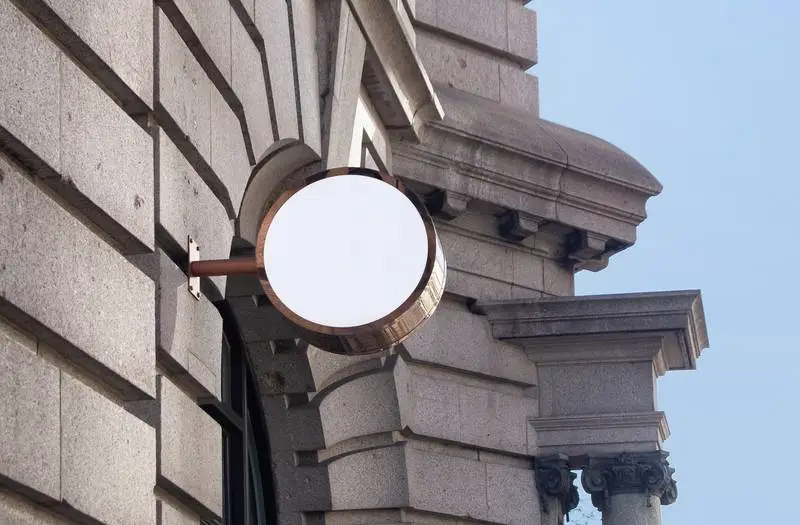 Round Metal Street Sign on Classic Stone Façade