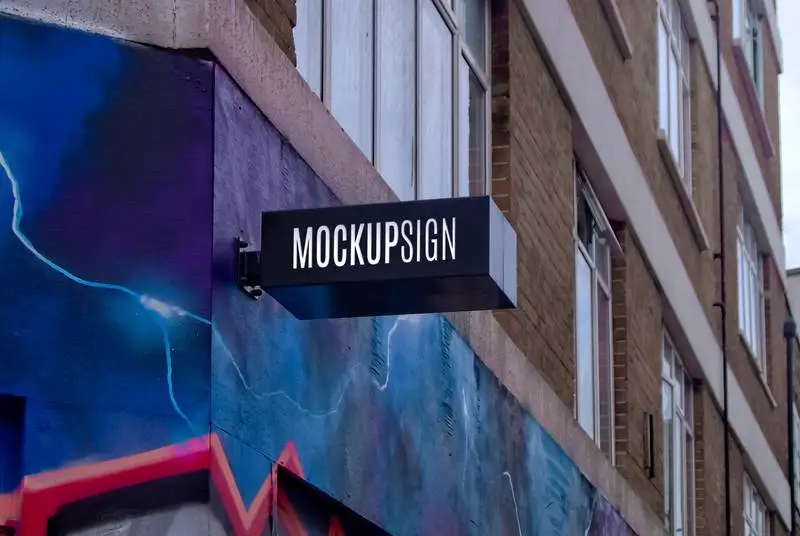 Black Sign Mockup with Text Effect on Brick Building and Graffiti Wall