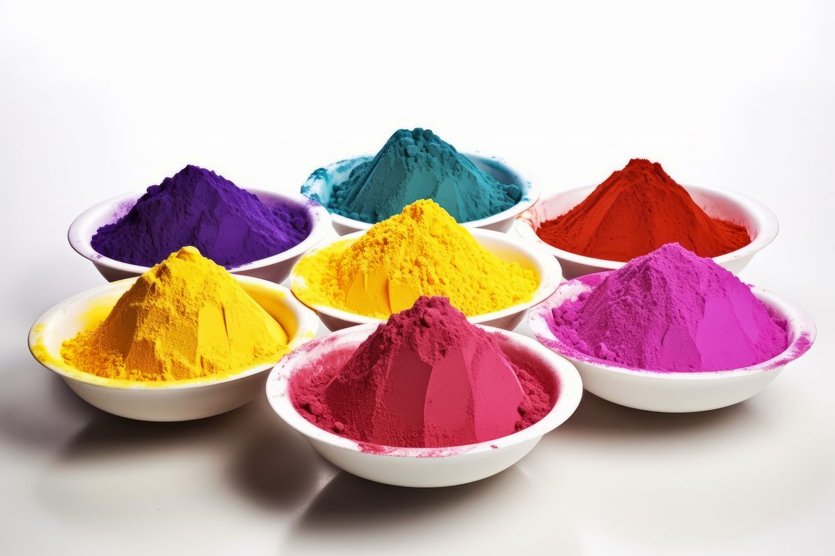 Bowls full of intensely coloured powder on white background for Holi Fest