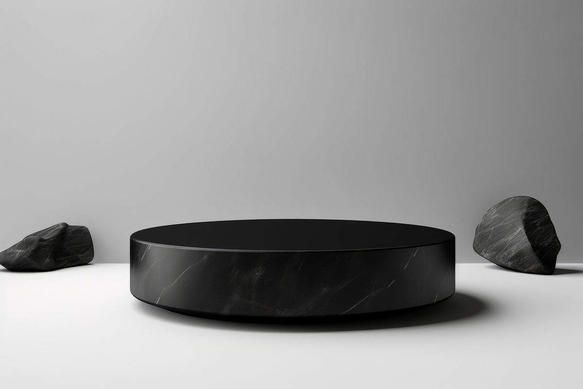 Elegant round black podium for product presentation surrounded by black stones on a white background