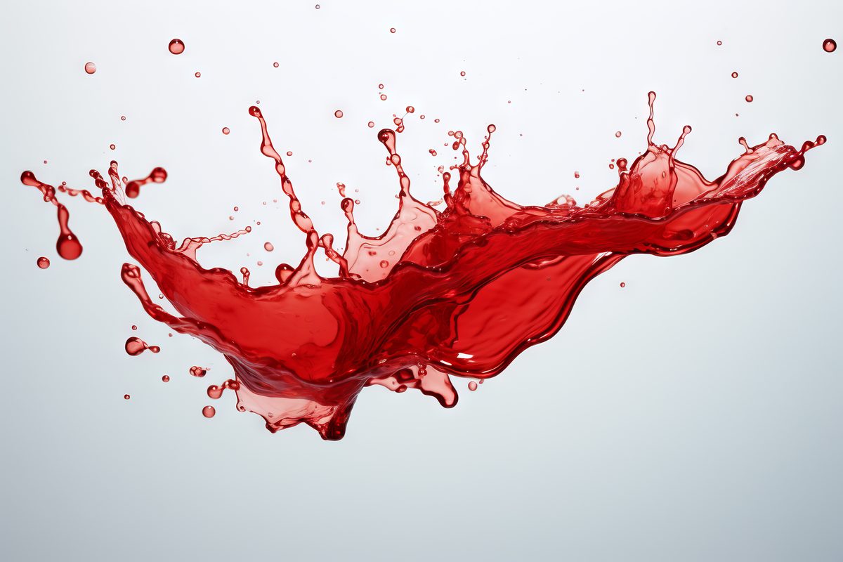 Image of red translucent liquid stain with many drops on white background
