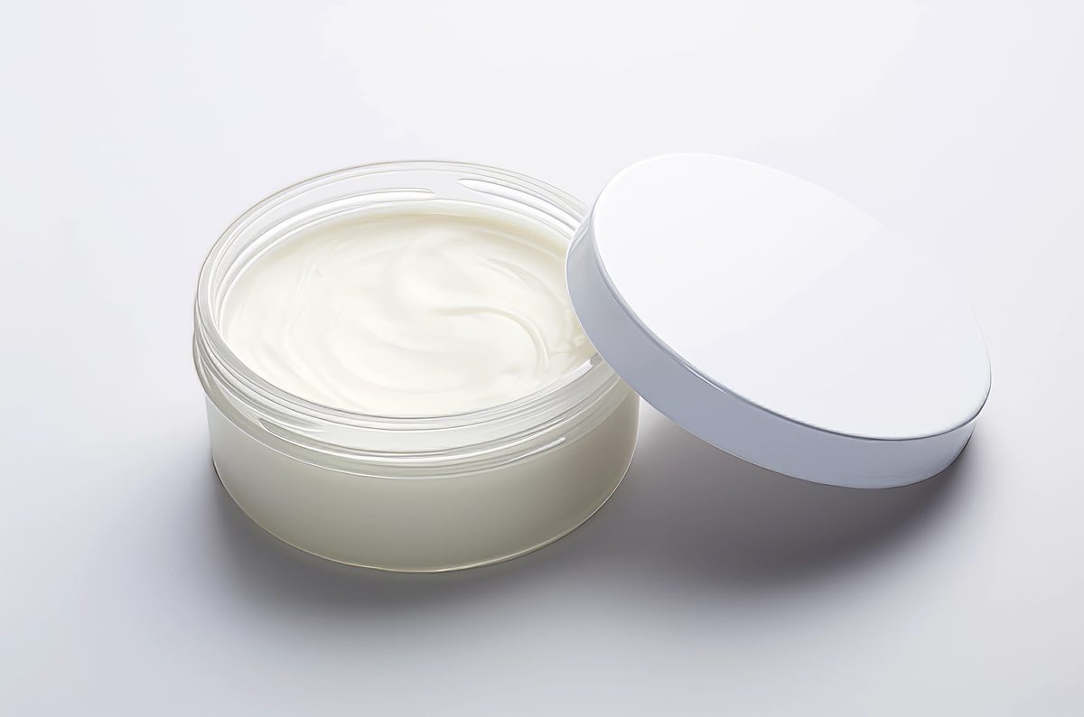 White glass cosmetic jar with isolated lid on white background