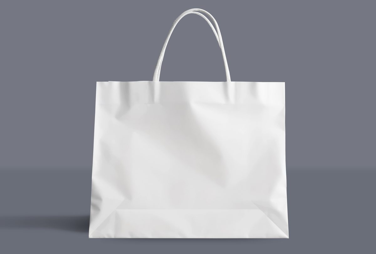 White paper shopping bag set on light blue background
