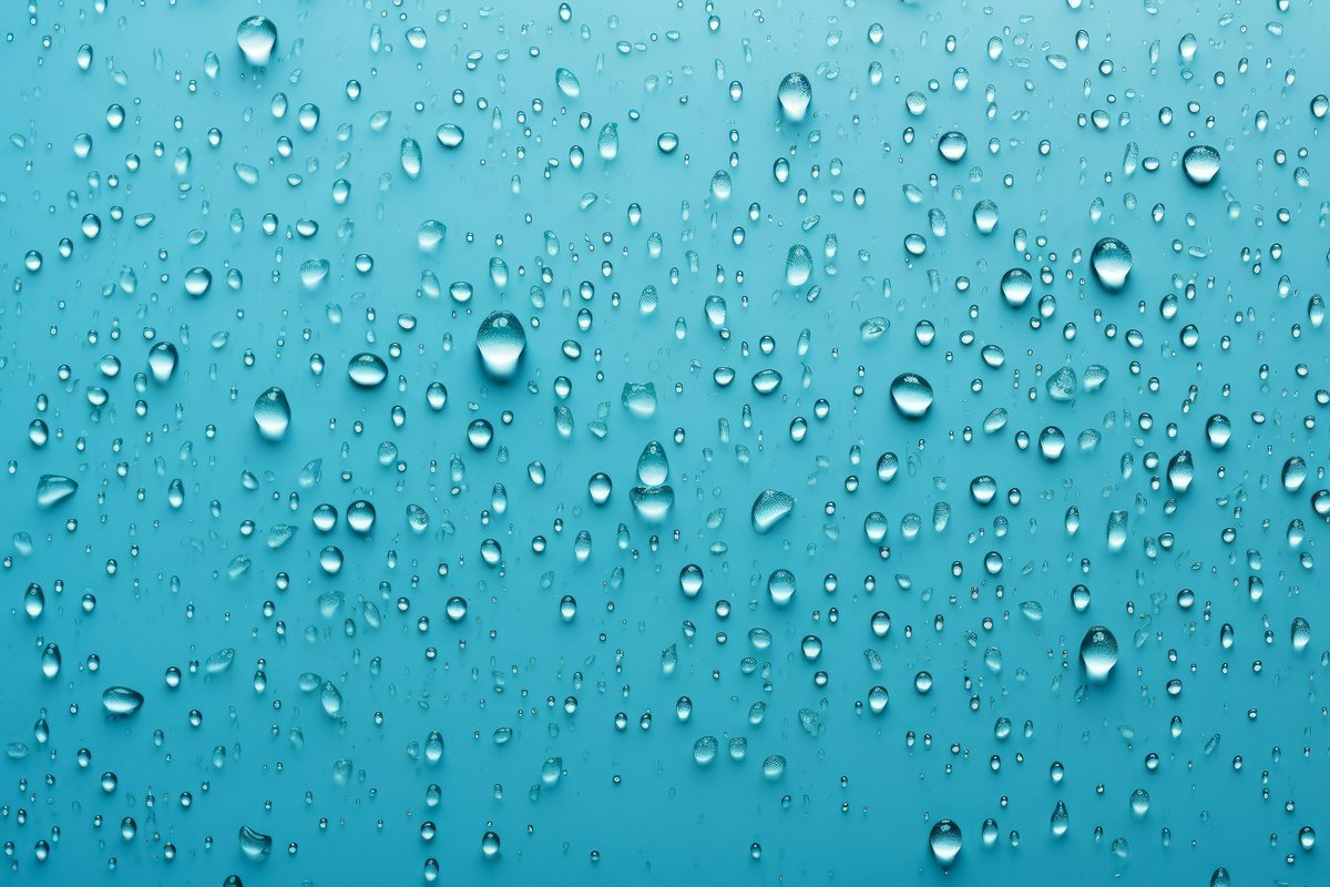 Background of water droplets splashed on a light blue surface