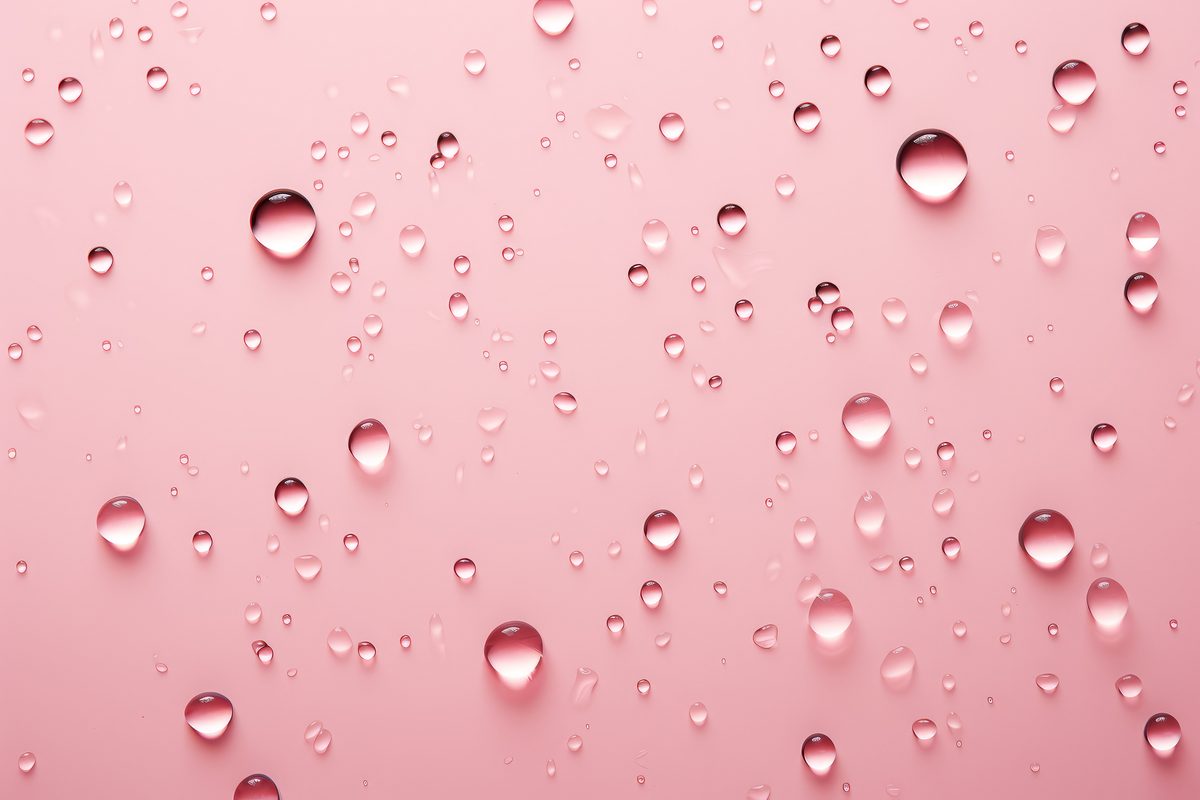 Background of water droplets splashed on a light pink surface