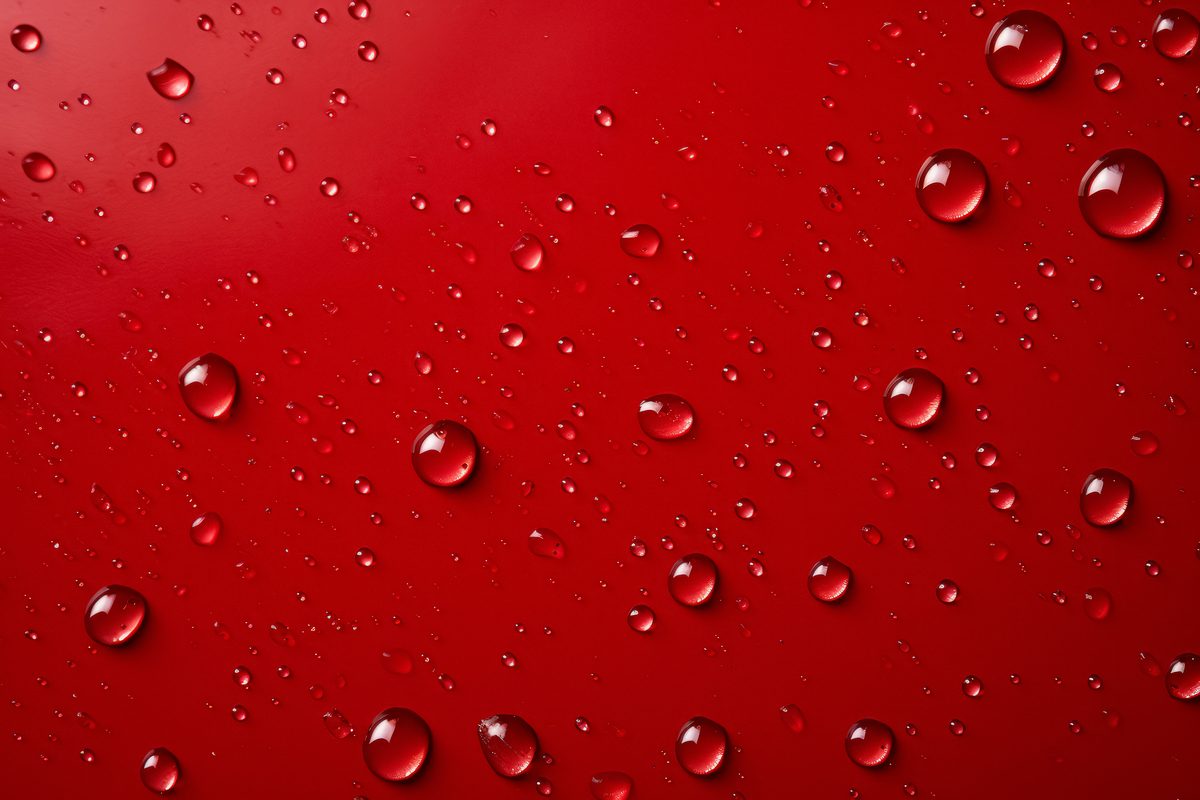 Background of water droplets splashed on a red surface